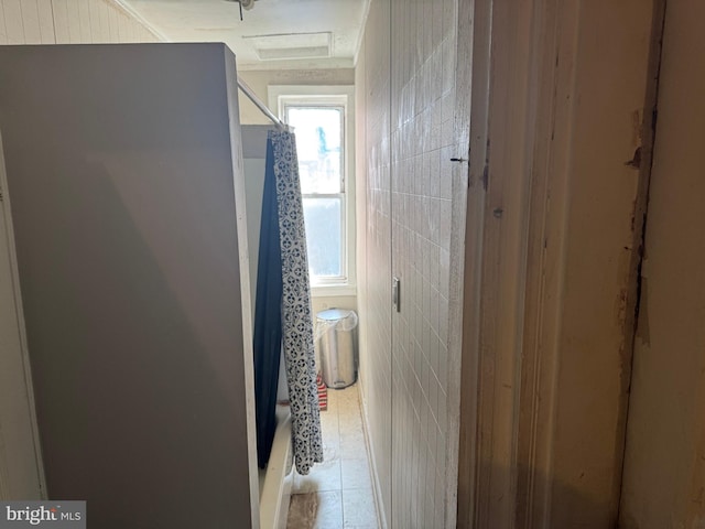 hall with tile patterned flooring and tile walls