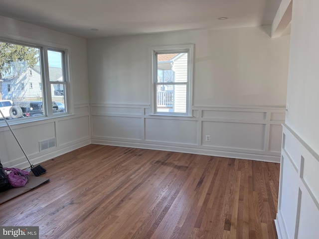 spare room featuring wood finished floors and visible vents