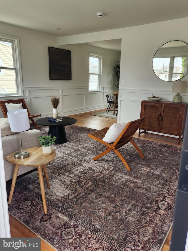 living room with wainscoting and wood finished floors