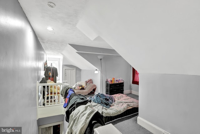 carpeted bedroom with baseboards and vaulted ceiling