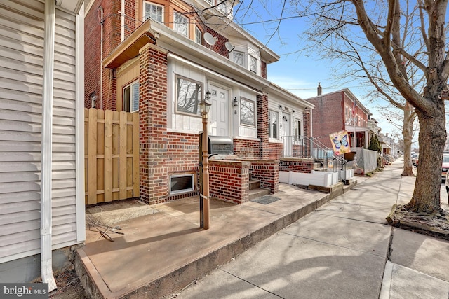 view of home's exterior featuring brick siding and fence