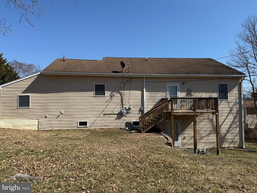 back of house with a wooden deck, a yard, and stairway