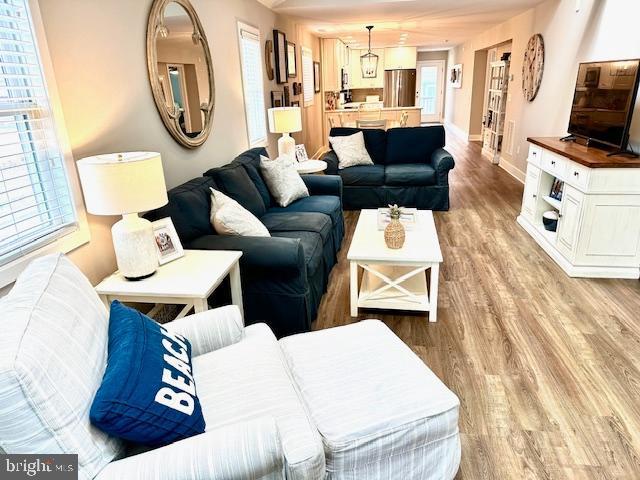 1 E Essex St, Fenwick Island, DE 19944 - living area featuring light wood finished floors, baseboards, and healthy amount of natural light