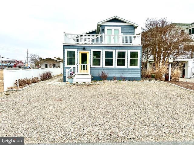 1 E Essex St, Fenwick Island, DE 19944 - view of front facade featuring a balcony and fence