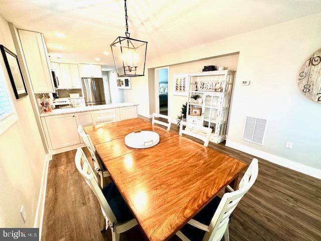 1 E Essex St, Fenwick Island, DE 19944 - dining room featuring dark wood finished floors, a chandelier, baseboards, and recessed lighting