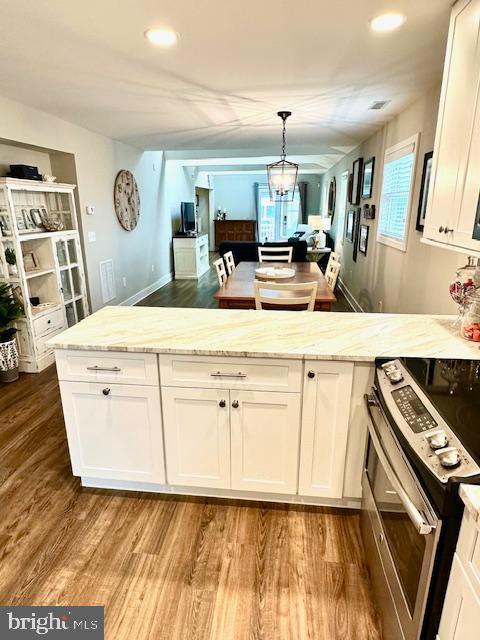 1 E Essex St, Fenwick Island, DE 19944 - kitchen with electric range, light wood-style flooring, white cabinets, a peninsula, and light stone counters