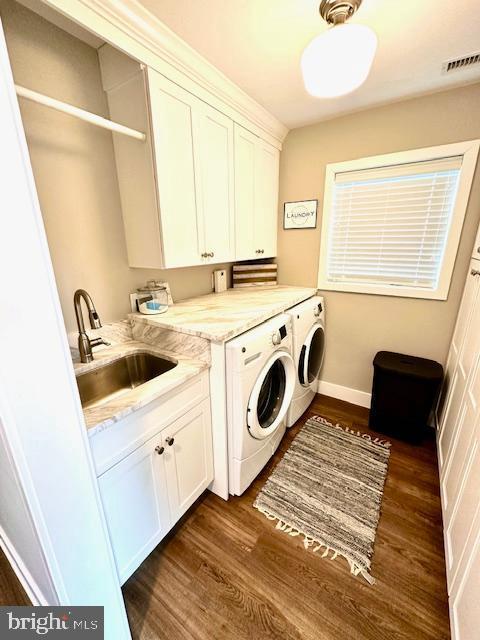 1 E Essex St, Fenwick Island, DE 19944 - washroom featuring washer and dryer, cabinet space, dark wood-style floors, and baseboards