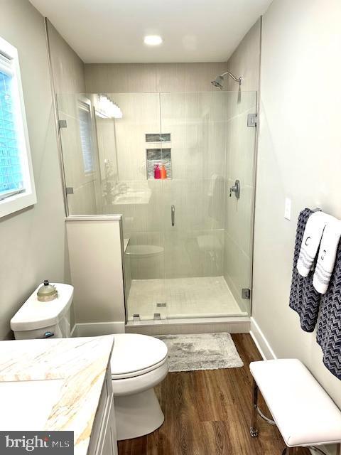 1 E Essex St, Fenwick Island, DE 19944 - full bathroom with wood finished floors, a shower stall, vanity, and toilet