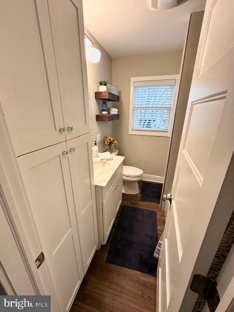 1 E Essex St, Fenwick Island, DE 19944 - bathroom with wood finished floors, toilet, vanity, and baseboards