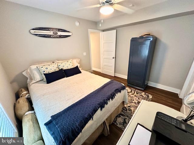 1 E Essex St, Fenwick Island, DE 19944 - bedroom with dark wood finished floors, baseboards, and a ceiling fan
