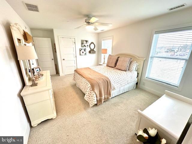 1 E Essex St, Fenwick Island, DE 19944 - bedroom with multiple windows, light colored carpet, and baseboards