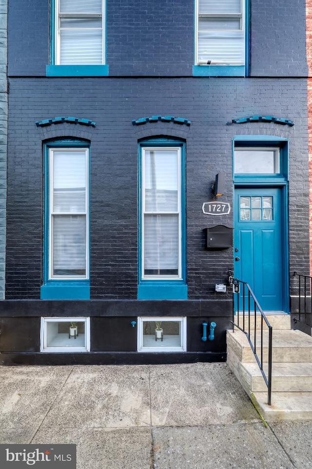 doorway to property with brick siding