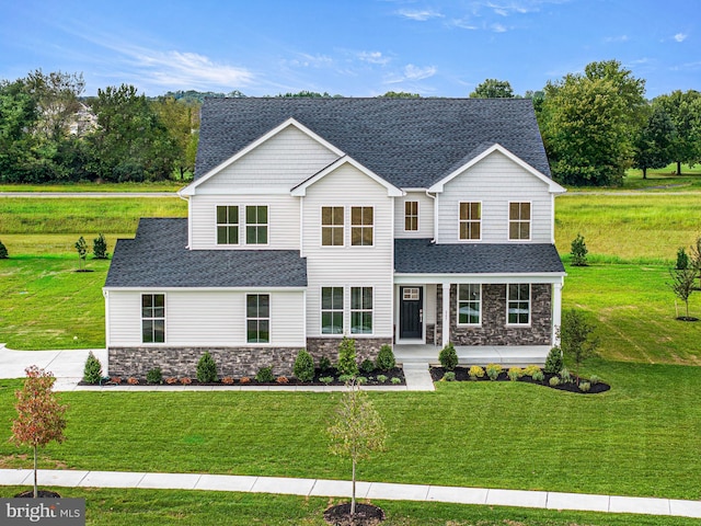 view of front facade featuring a porch, stone siding, a front yard, and roof with shingles