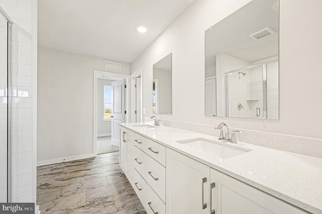 bathroom with a sink, visible vents, marble finish floor, and a shower stall