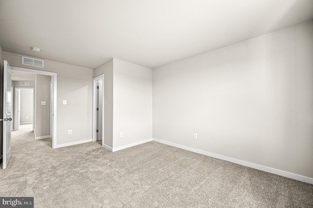 unfurnished bedroom with visible vents, baseboards, and light colored carpet