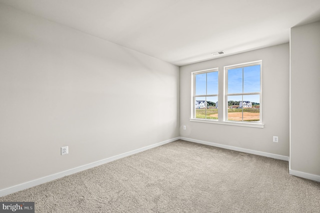 carpeted empty room with visible vents and baseboards