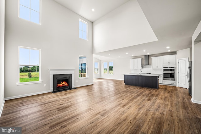 unfurnished living room with dark wood finished floors, a fireplace with flush hearth, and a wealth of natural light