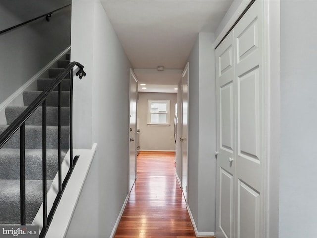 hallway with wood-type flooring and baseboards