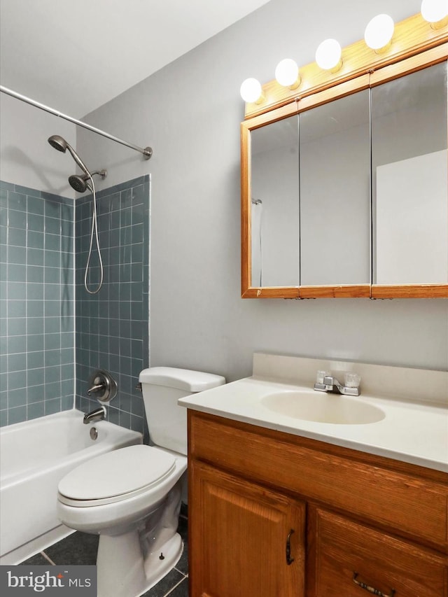 bathroom with tile patterned floors, bathing tub / shower combination, vanity, and toilet