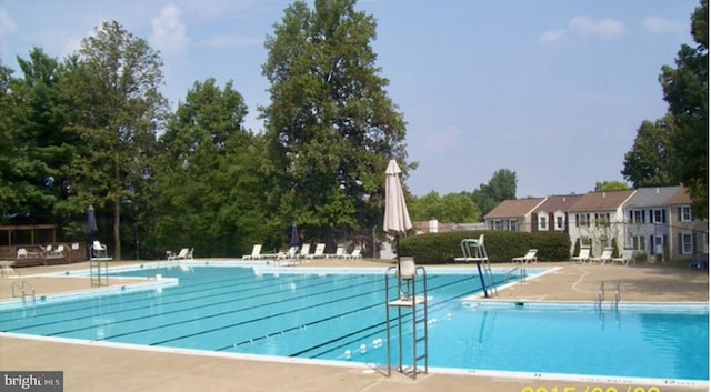 community pool featuring a patio and fence