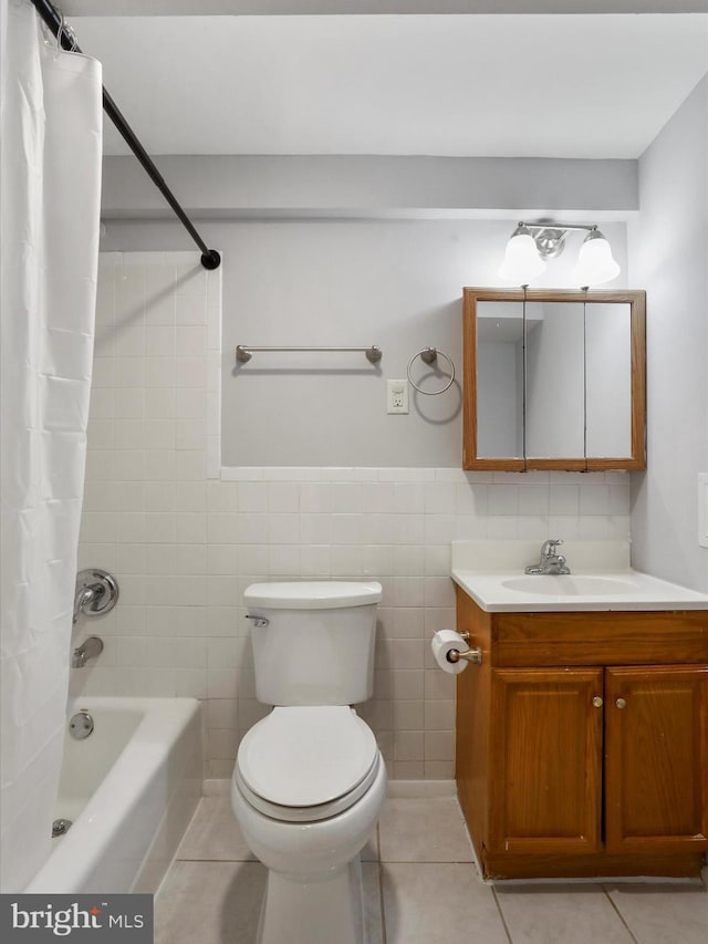 bathroom with vanity, toilet, tile walls, tile patterned floors, and shower / bath combo with shower curtain
