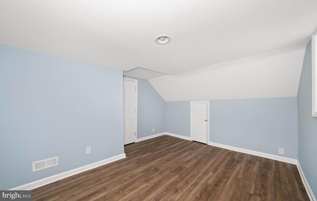 bonus room with dark wood finished floors, lofted ceiling, baseboards, and visible vents