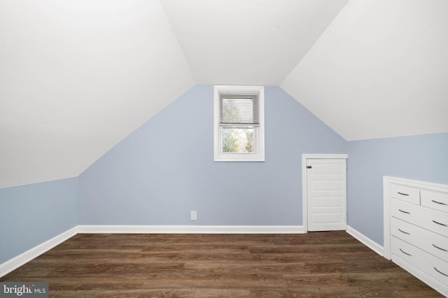 bonus room with baseboards, dark wood finished floors, and vaulted ceiling