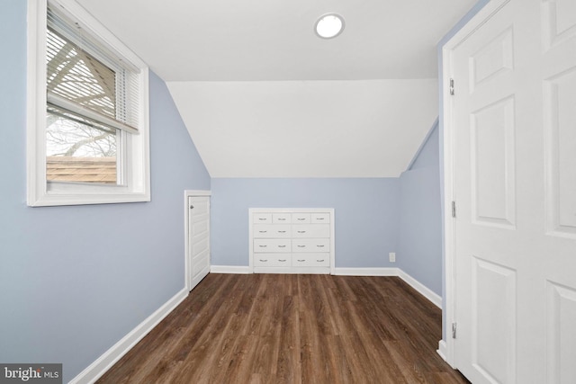 additional living space with dark wood finished floors, baseboards, and vaulted ceiling