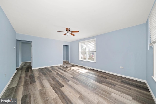 spare room with visible vents, baseboards, ceiling fan, and dark wood-style flooring