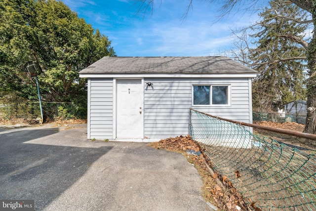 view of outbuilding featuring an outdoor structure and fence