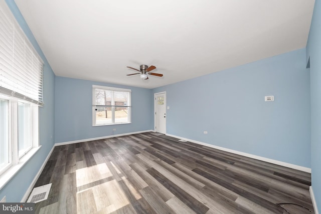 unfurnished room with wood finished floors, baseboards, visible vents, and ceiling fan