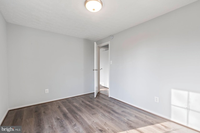 unfurnished room featuring wood finished floors and baseboards