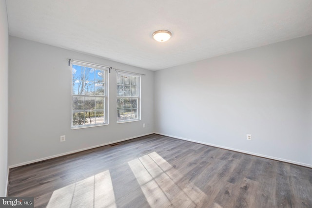 empty room featuring baseboards and wood finished floors