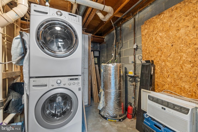 laundry area featuring laundry area, concrete block wall, a wall mounted AC, and stacked washer / drying machine