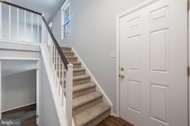 stairway with baseboards and wood finished floors