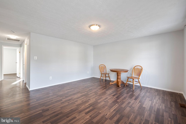 living area with dark wood-style floors, visible vents, and baseboards