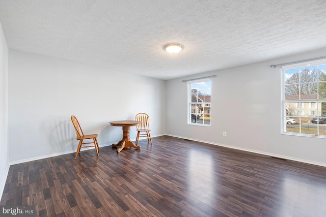 sitting room featuring dark wood-style floors, plenty of natural light, baseboards, and visible vents