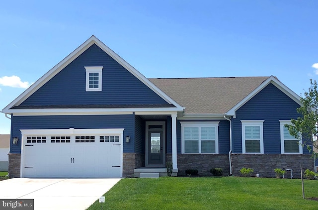 view of front of property with a shingled roof, a front lawn, a garage, stone siding, and driveway