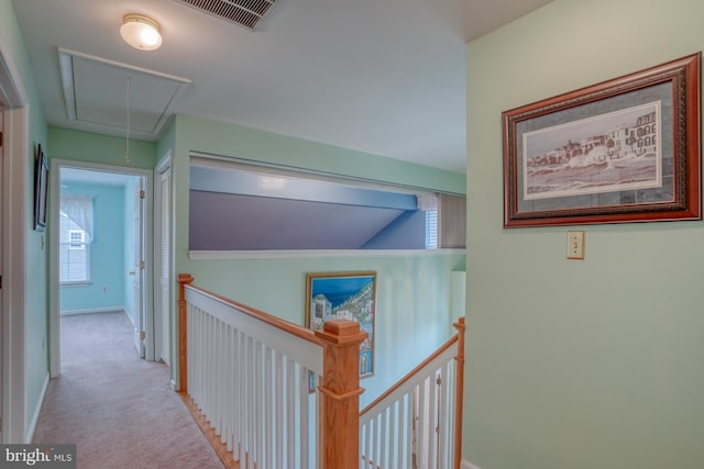 hallway featuring attic access, an upstairs landing, carpet, and visible vents