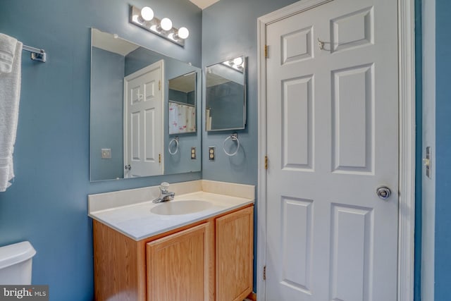 bathroom featuring toilet and vanity