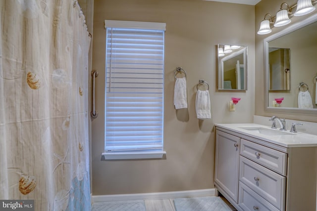 full bathroom with a shower with curtain, vanity, and baseboards