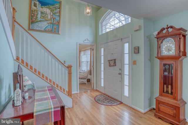 entryway with stairway, baseboards, and wood finished floors