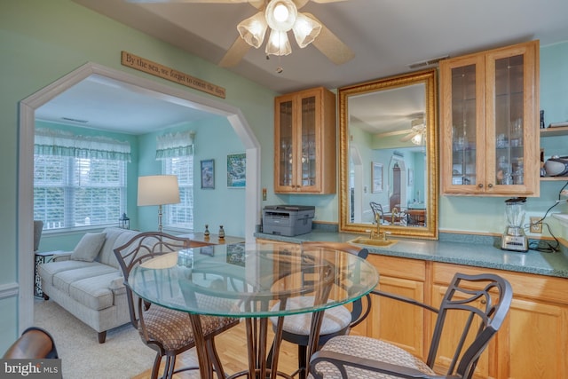 dining area with visible vents, arched walkways, and a ceiling fan