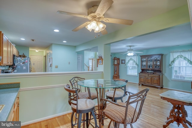 dining room featuring plenty of natural light, baseboards, light wood-type flooring, and ceiling fan