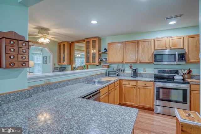 kitchen featuring visible vents, ceiling fan, light wood-style floors, stainless steel appliances, and a sink