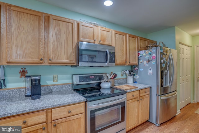 kitchen featuring light wood-style floors, light brown cabinets, and stainless steel appliances