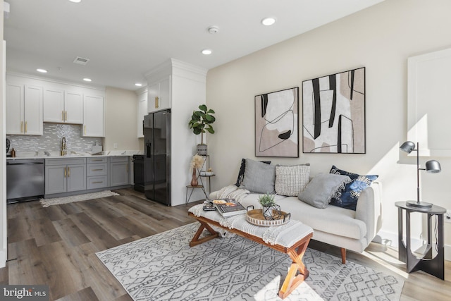 living room with visible vents, recessed lighting, and dark wood-type flooring