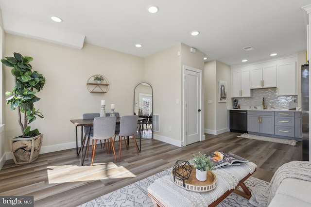 living area featuring recessed lighting, baseboards, and dark wood-style flooring