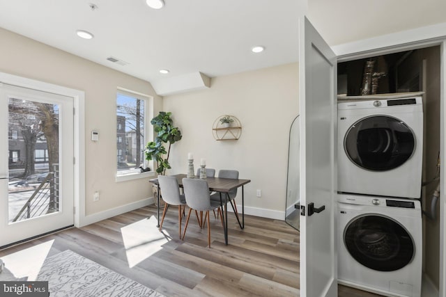 washroom featuring baseboards, light wood-type flooring, laundry area, recessed lighting, and stacked washer and clothes dryer