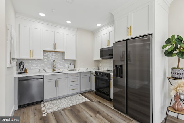 kitchen featuring dark wood-style floors, white cabinetry, black appliances, and a sink